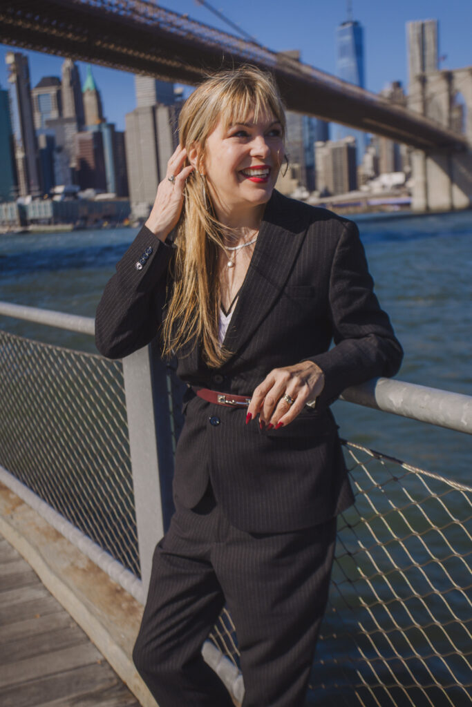 woman standing near water and a bridge in New York City