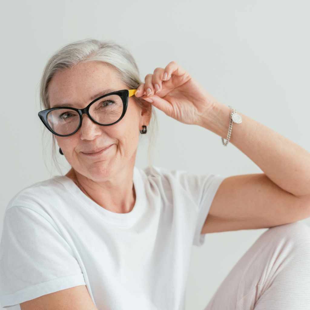 woman smiling at the camera, wearing classes